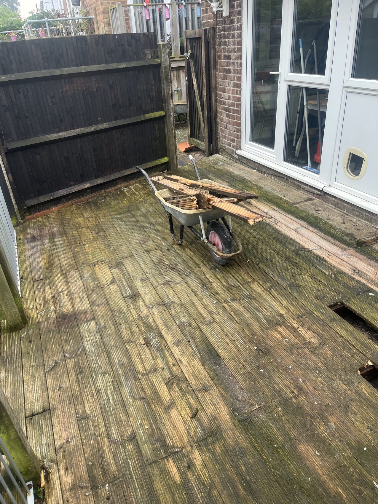 Before: the old decking and dark fence line, worn and shaded.
