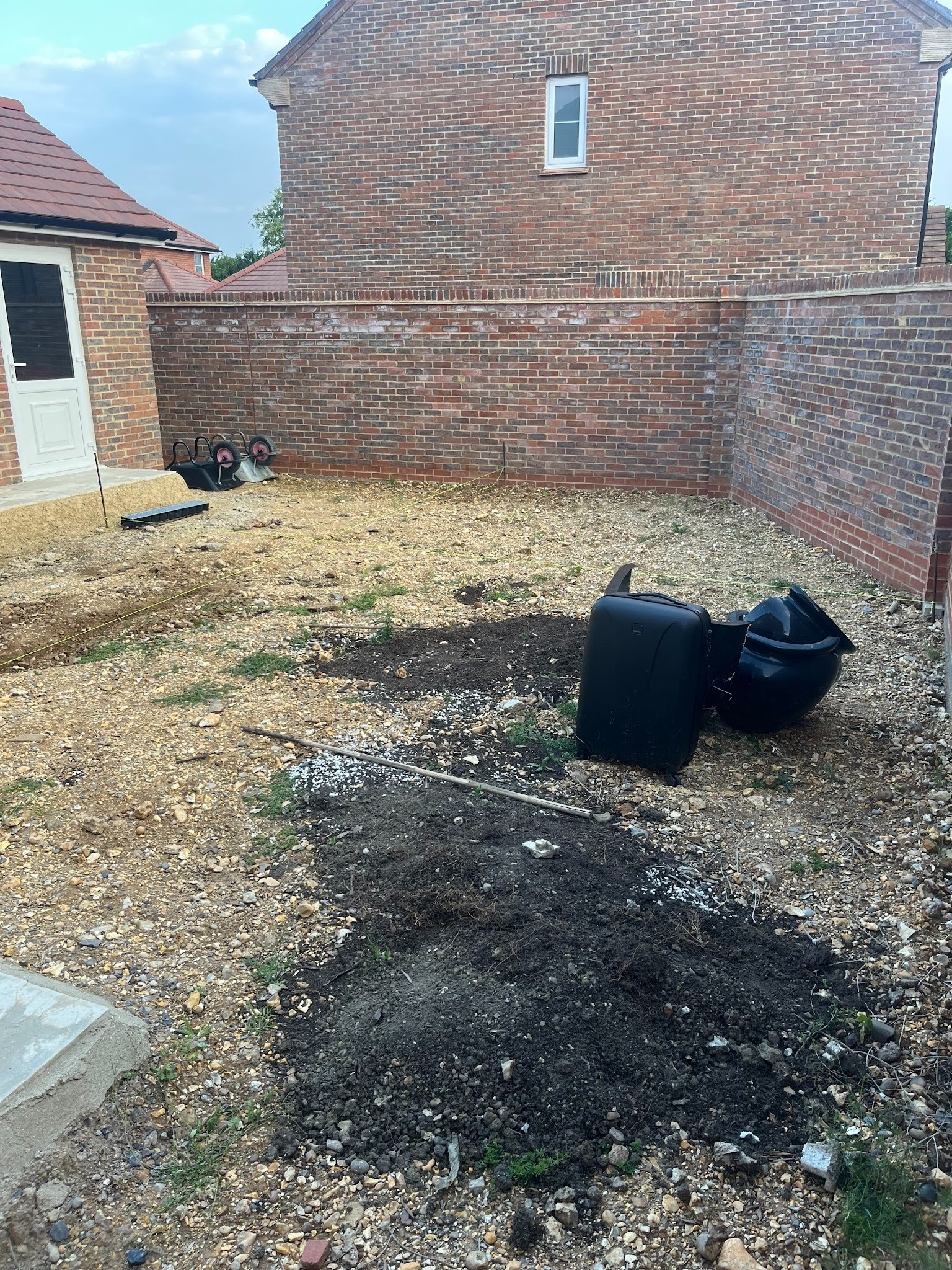 The garden as handed over by the developer &mdash; builder's spoil from boundary wall to boundary wall, the standard new-build starting point before Etonic took over.