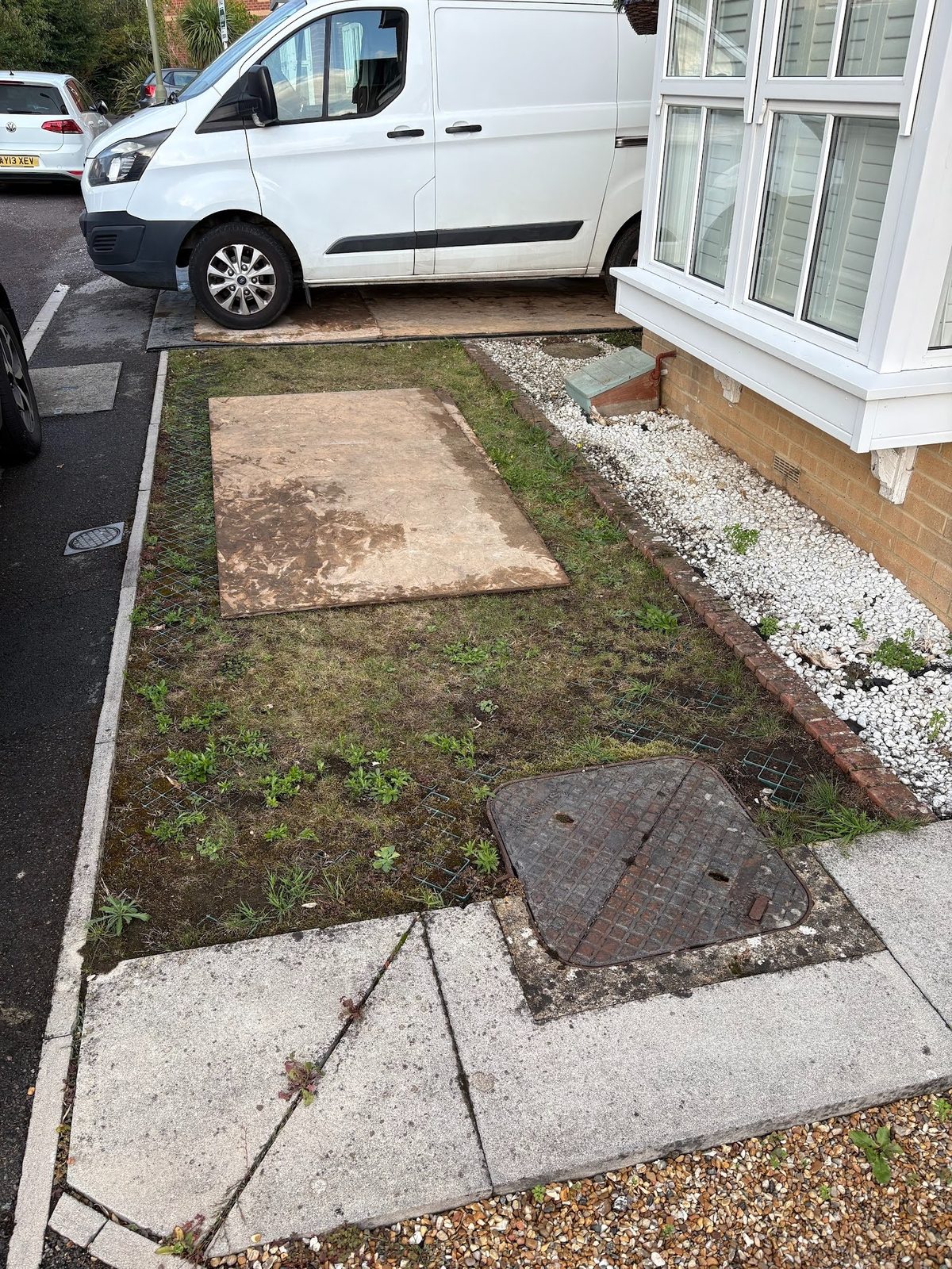 Before: the tired front garden — threadbare grass, an uneven path and old underlay showing through the bare patches.