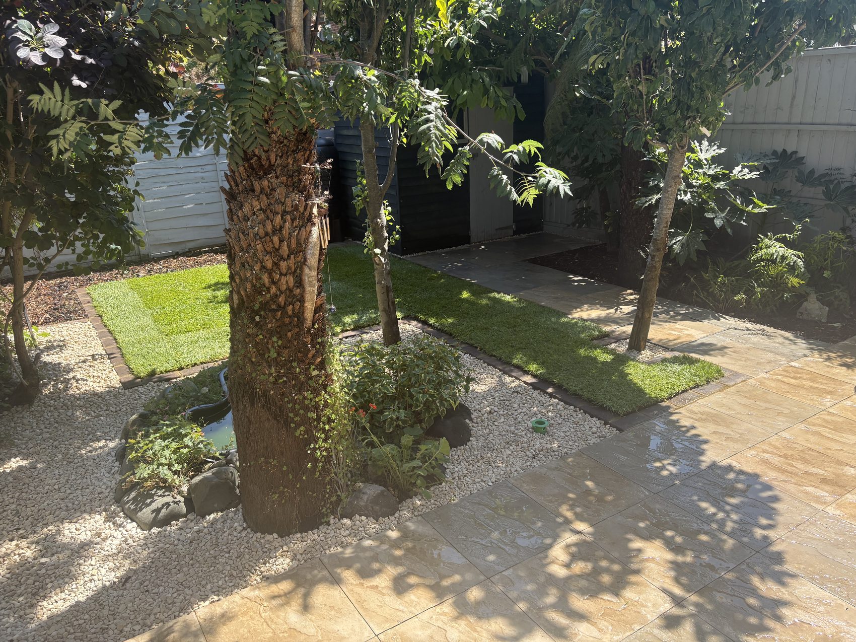 The new lawn panels edged in matching brick, running down towards the new patio.