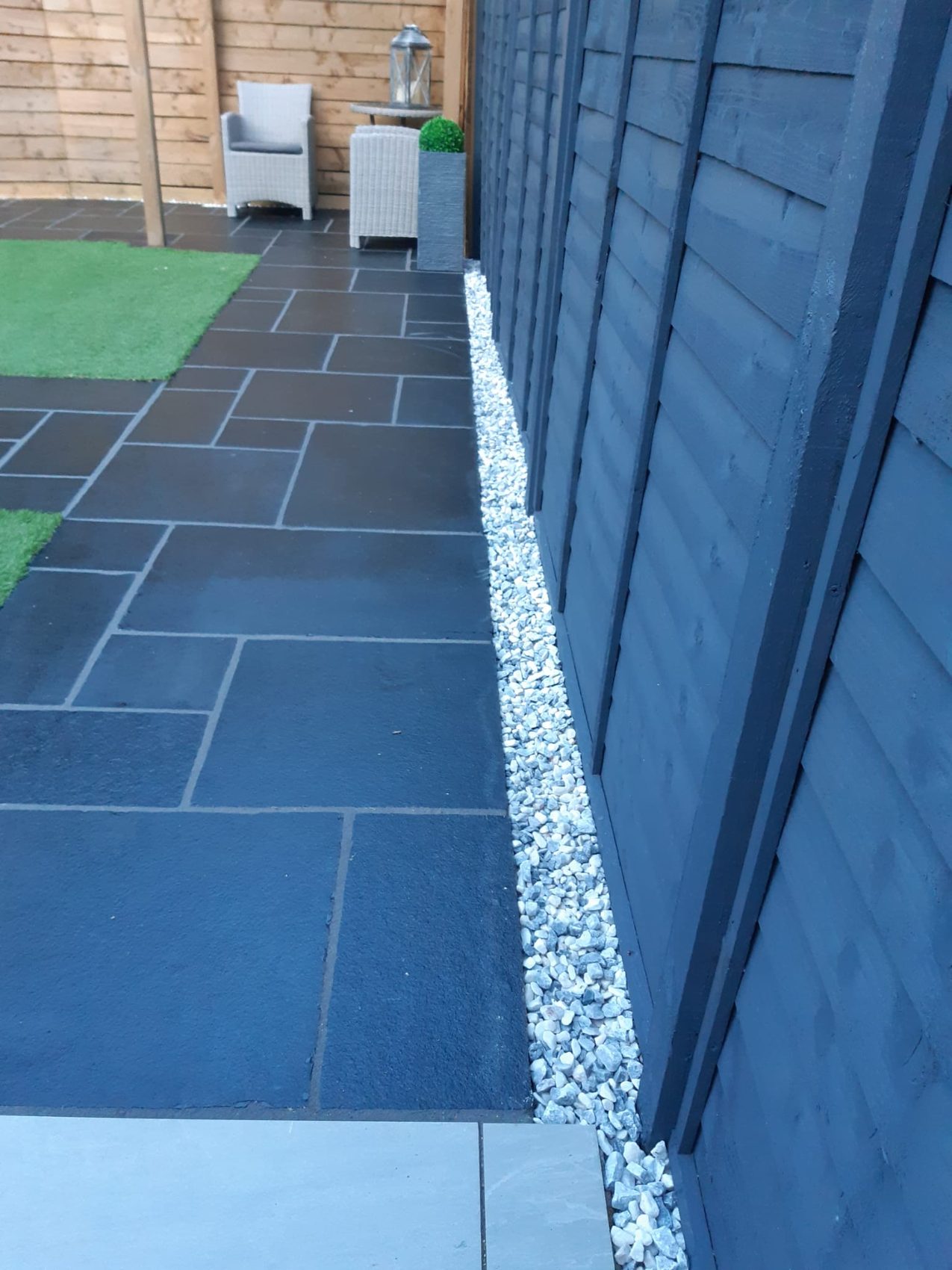 Polar Ice decorative stone bordering the revitalised black limestone paving along the fence line.