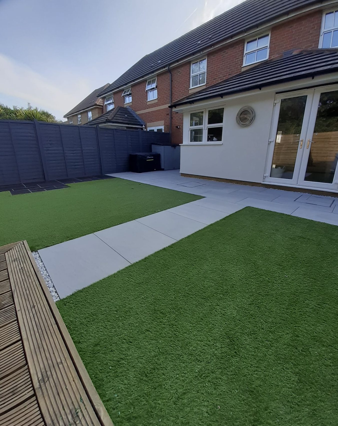 Finished Segensworth garden: a new Kandla Grey porcelain patio and path framed by artificial lawn on both sides
