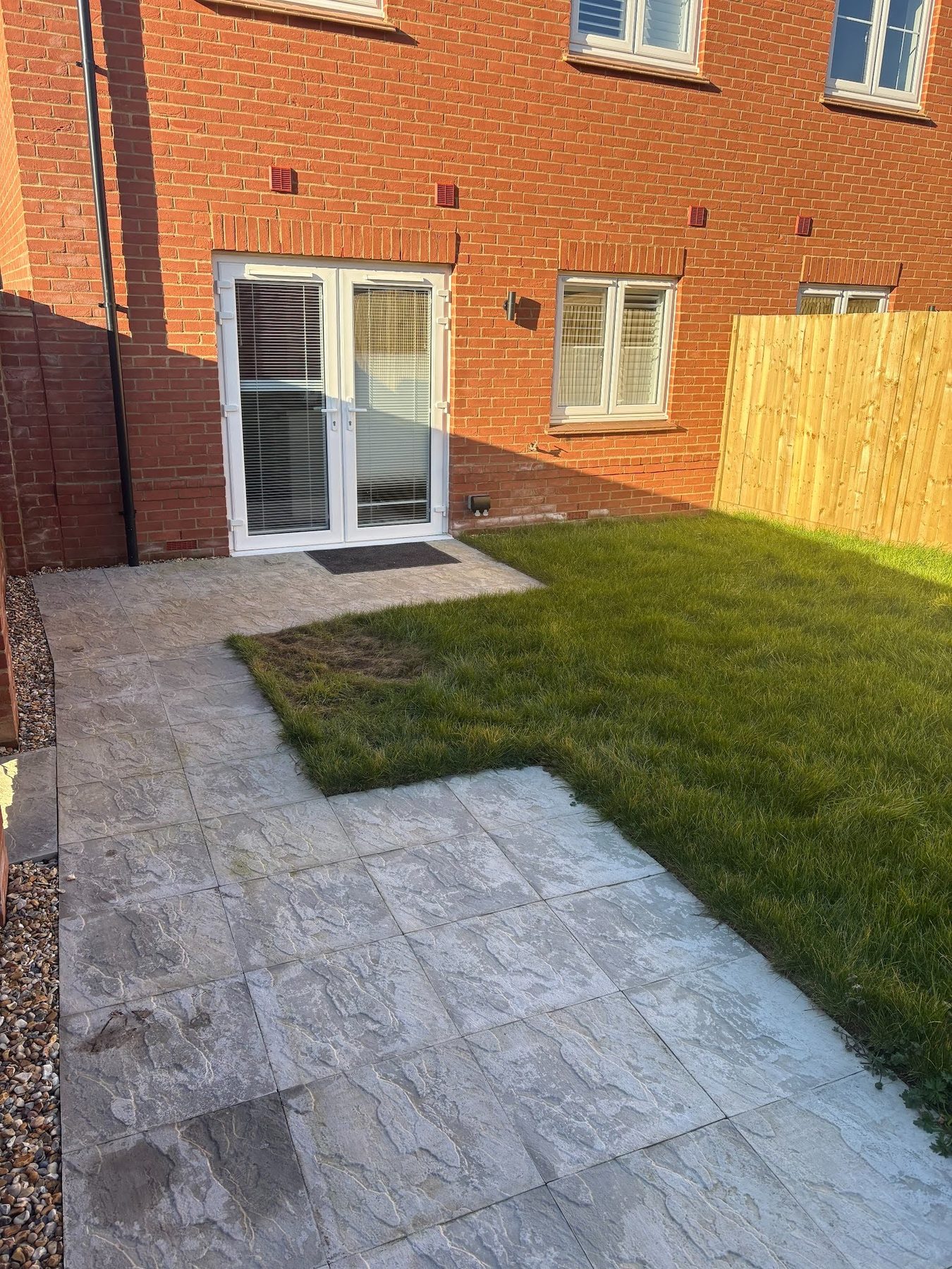 The principal terrace looking back to the house &mdash; lighter textured porcelain laid up to the door threshold.