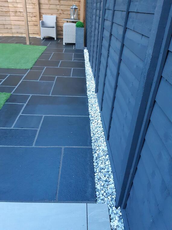 Garden refresh, Segensworth -- Polar Ice decorative stone bordering the revitalised black limestone paving along the fence line.