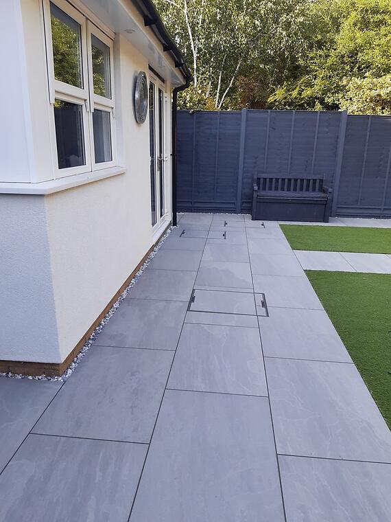 Garden refresh, Segensworth -- Inspection covers recessed and cut flush into the paving so they read as part of the surface, not a patch on it.