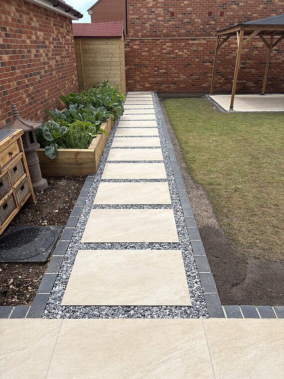 Curved patio, Warsash -- The stepping-stone pathway, edged in black limestone and finished with Polar Ice chippings, leading past the raised vegetable beds.