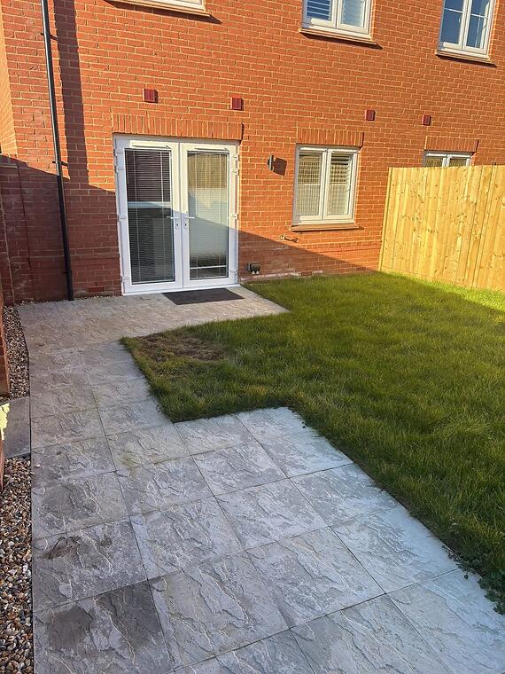 Full hardscape, Warsash -- The principal terrace looking back to the house — lighter textured porcelain laid up to the door threshold.